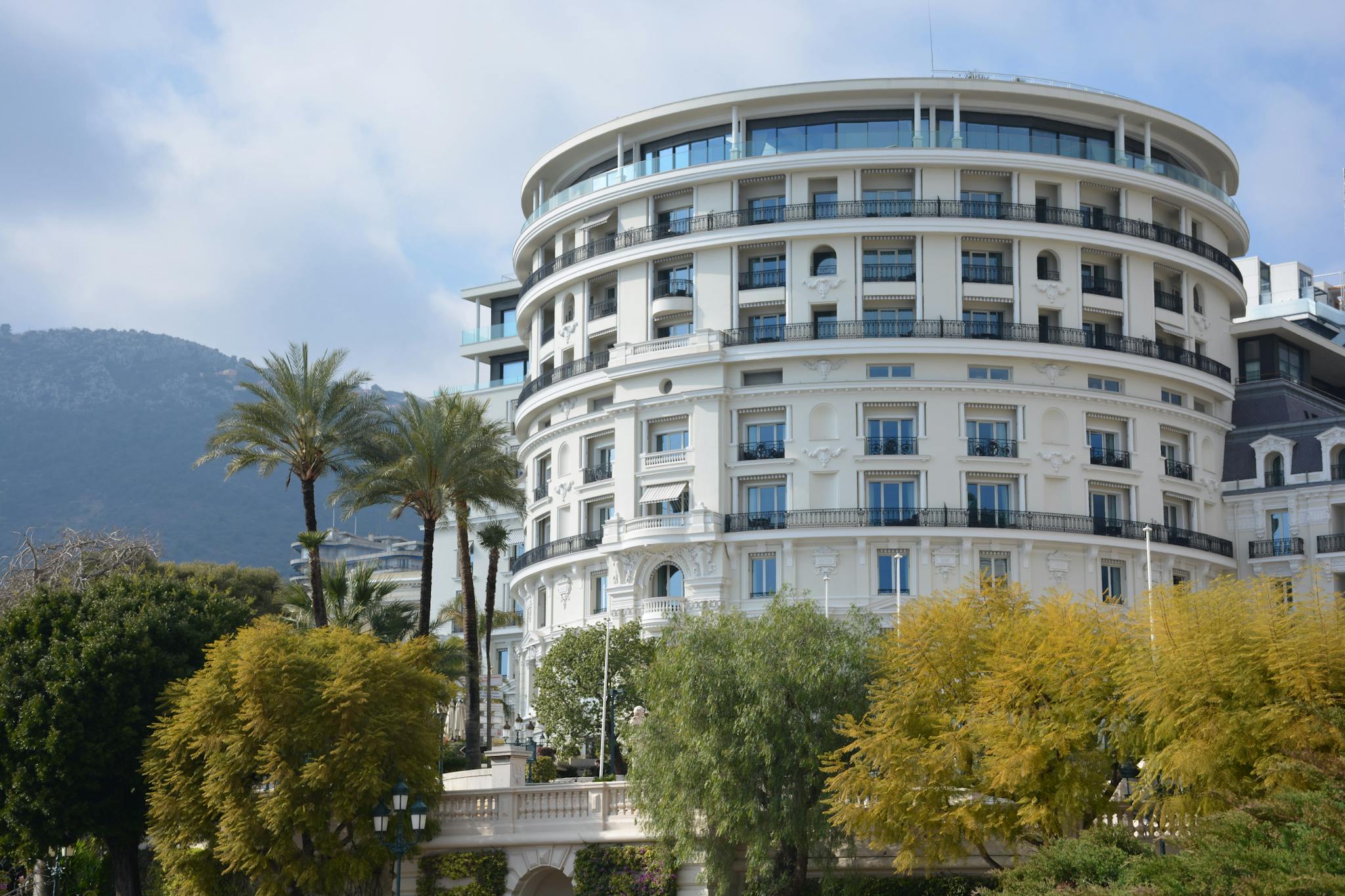 Luxurious round hotel with palm trees, offering an elegant getaway.