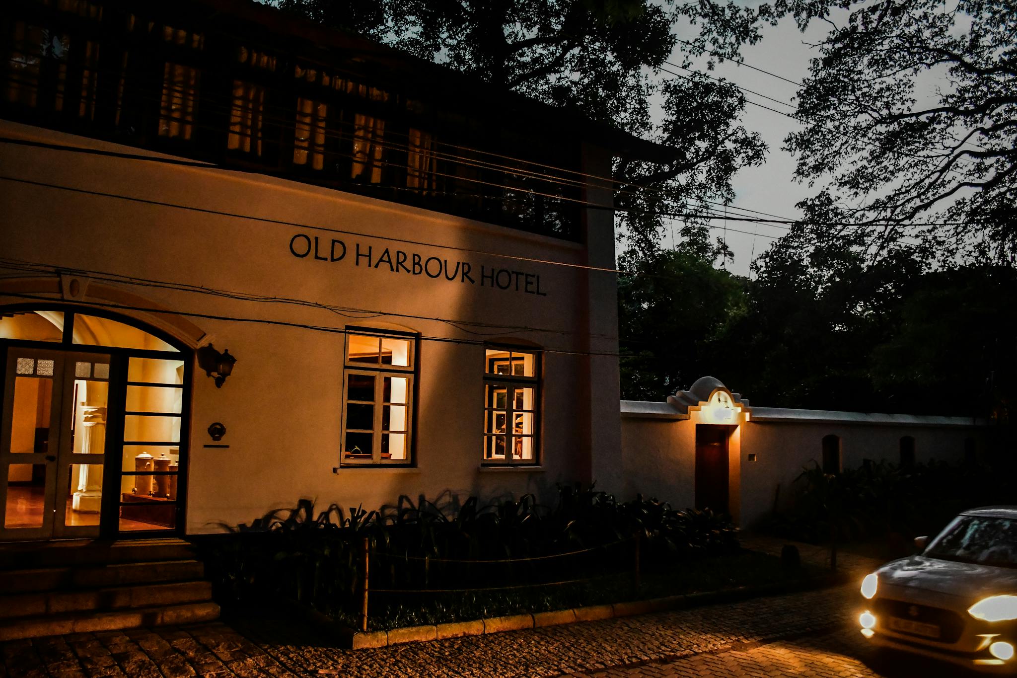 Old Harbour Hotel illuminated at dusk with vintage charm and intricate architecture.